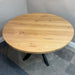 Round wooden table in a room with a gray carpet